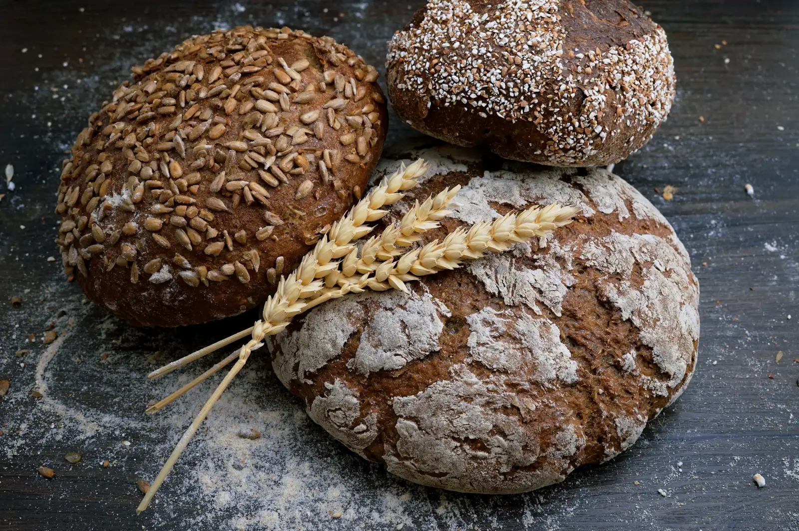 Pains au levain et épis de blé sur une table en bois