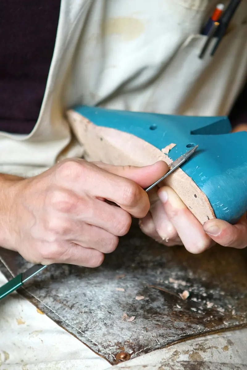Artisan taillant une semelle au couteau